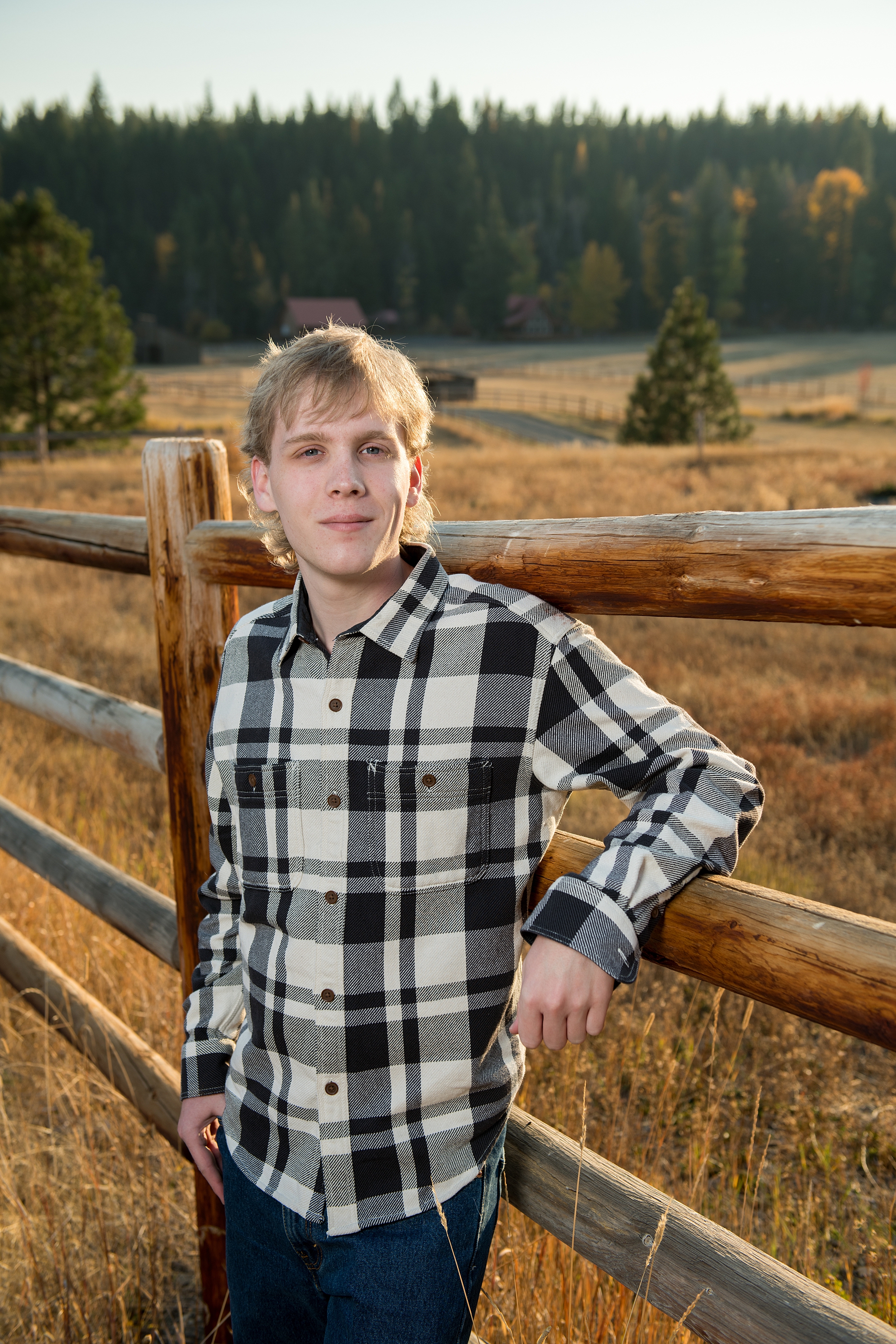 High school Senior Portraits in Roslyn boy leaning against a wooden fence