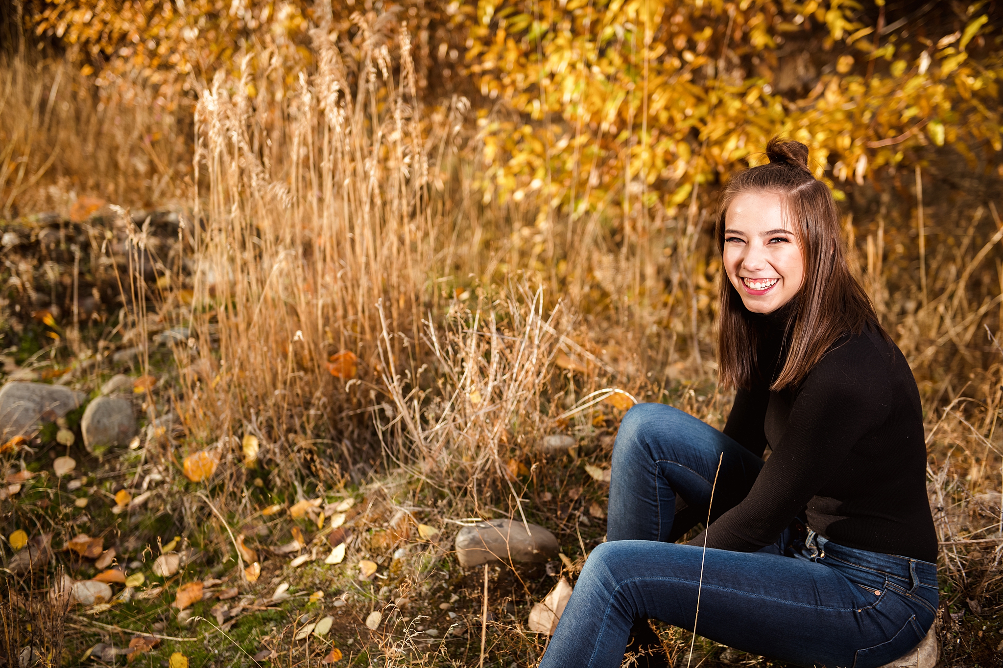 Girl sitting in open field near Yakima River in Cle Elum Senior Portrait Location