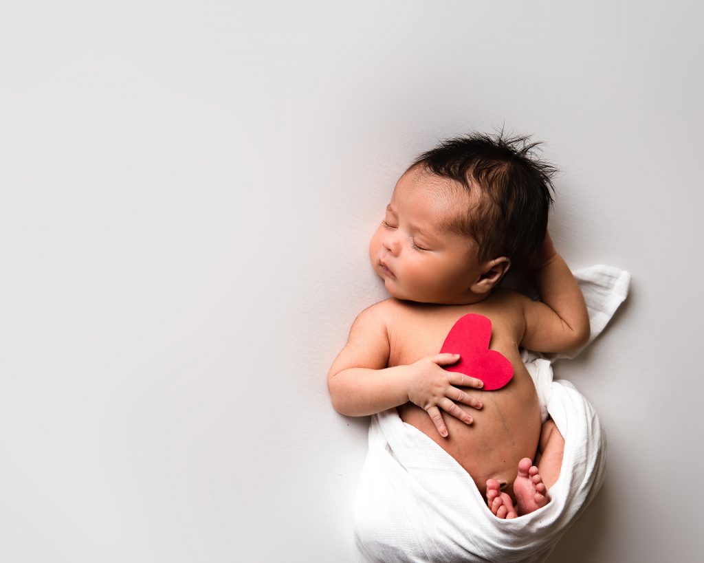 Newborn baby on white backdrop Everything You Need to Know About Newborn Photography