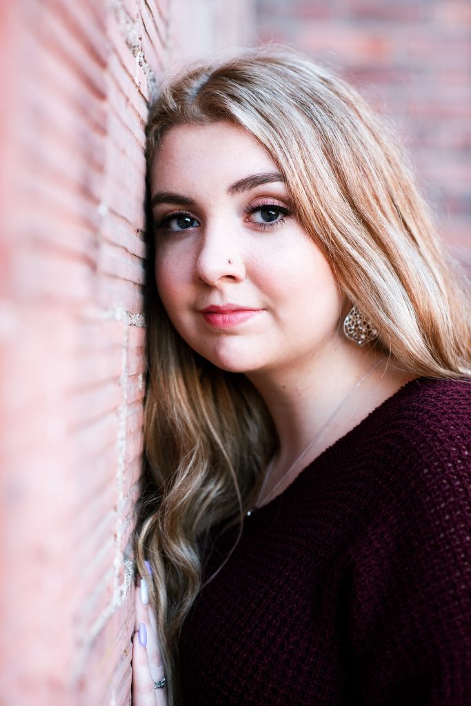 Traditional photo of a high school girl against a brick wall Cle Elum Senior Photographer