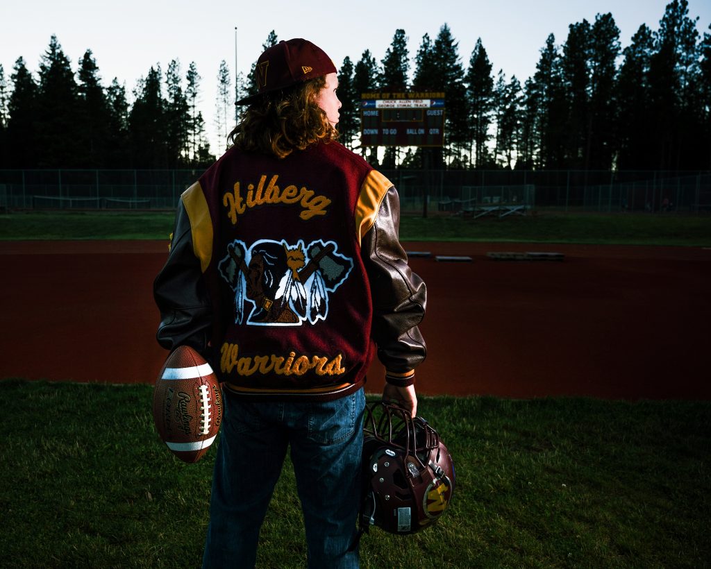 Cle Elum Senior Photographer male athlete in letterman jacket holding football and helmet