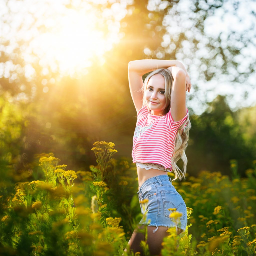 Senior Photography in Ellensburg, a young blonde girl with long hair posing with her arms above her head