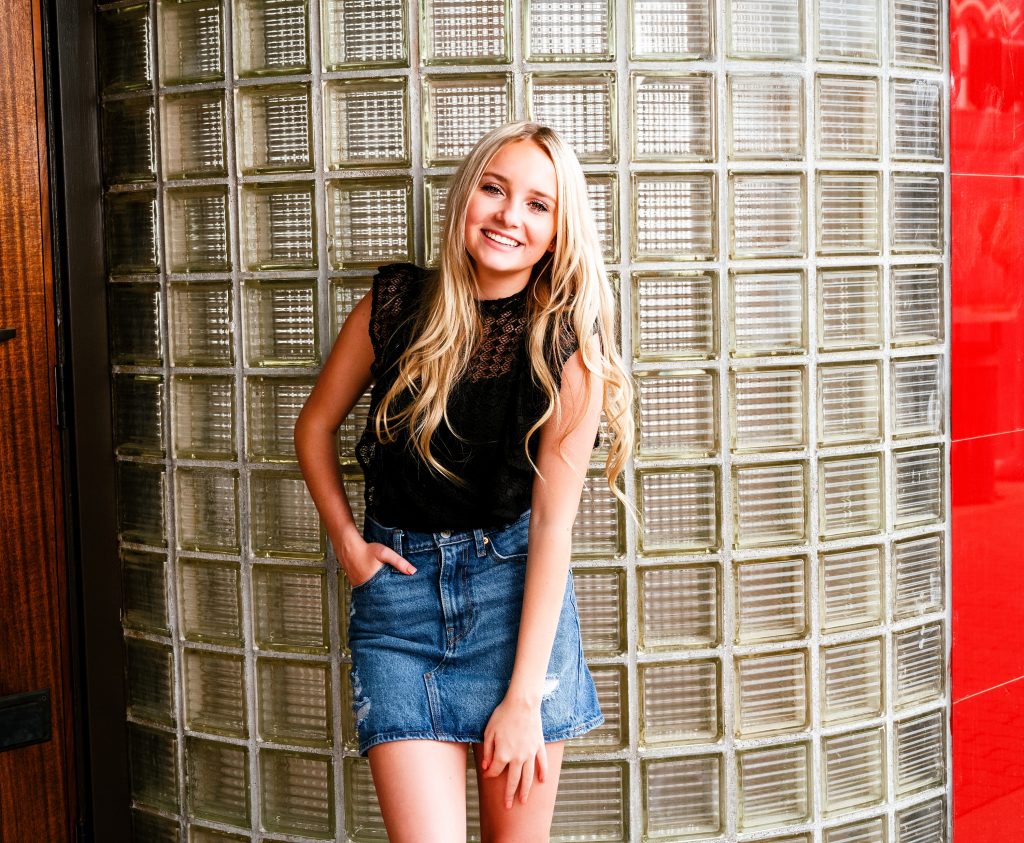 Senior Photography in Ellensburg, a young blonde girl with long hair posing in a jean skirt and black top