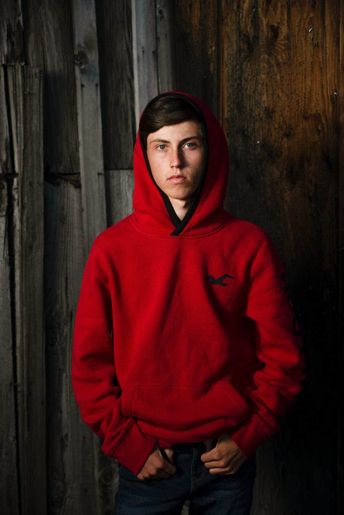 High school student in red hoody posing for picture by Mary Maletzke Photography