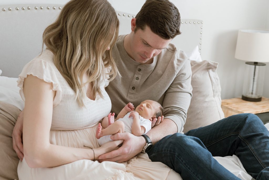 Photo of new parents snuggling baby daughter on a bed Family photography in Ellensburg 