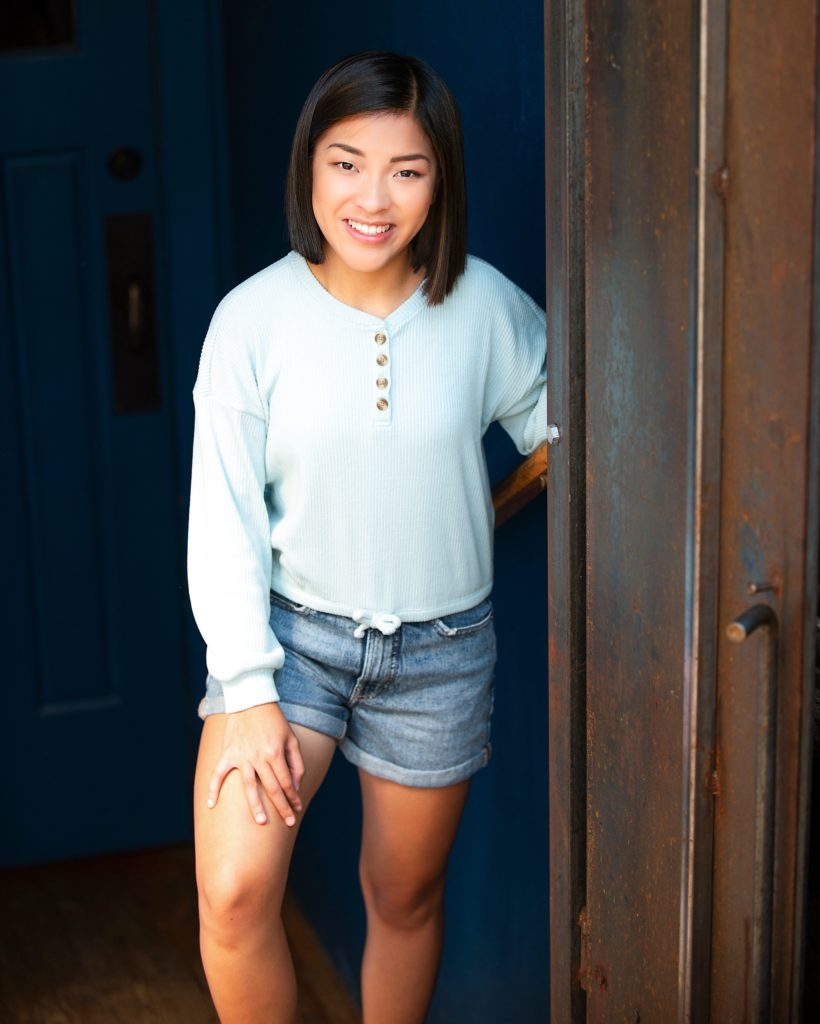Pretty Asian teenage girl poses in the doorway of a boutique store in Cle Elum WA