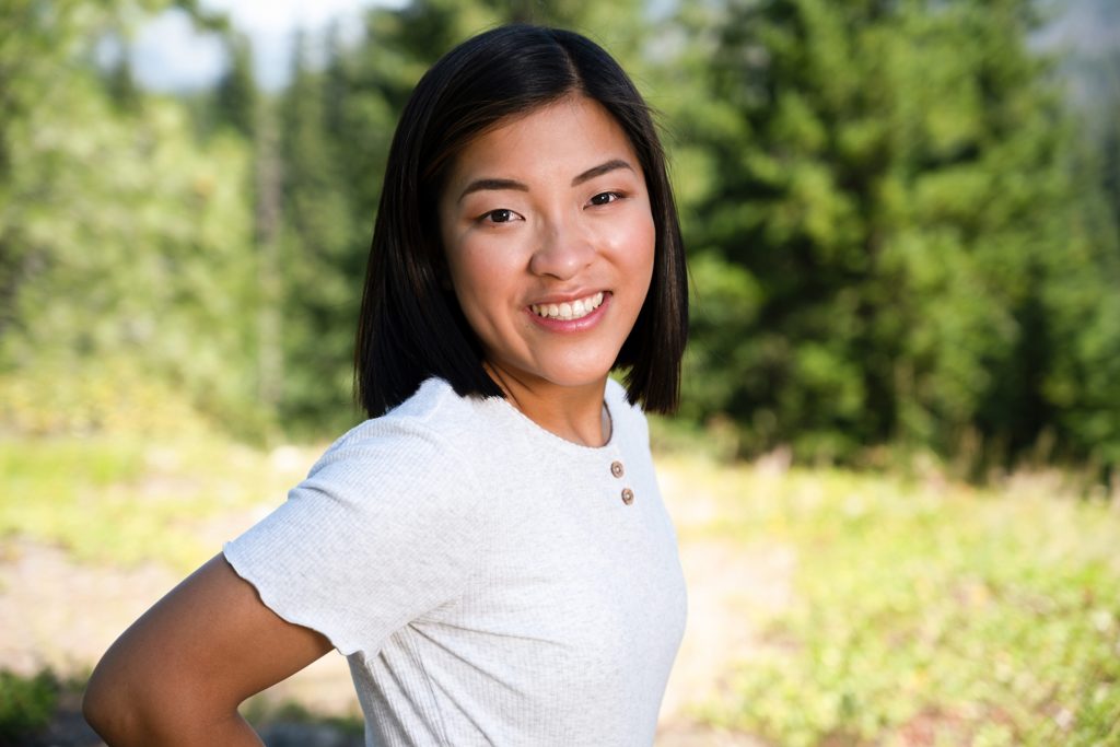 Asian high school senior smiles at the camera in a white top with buttons taken by Suncadia Senior Photographer 