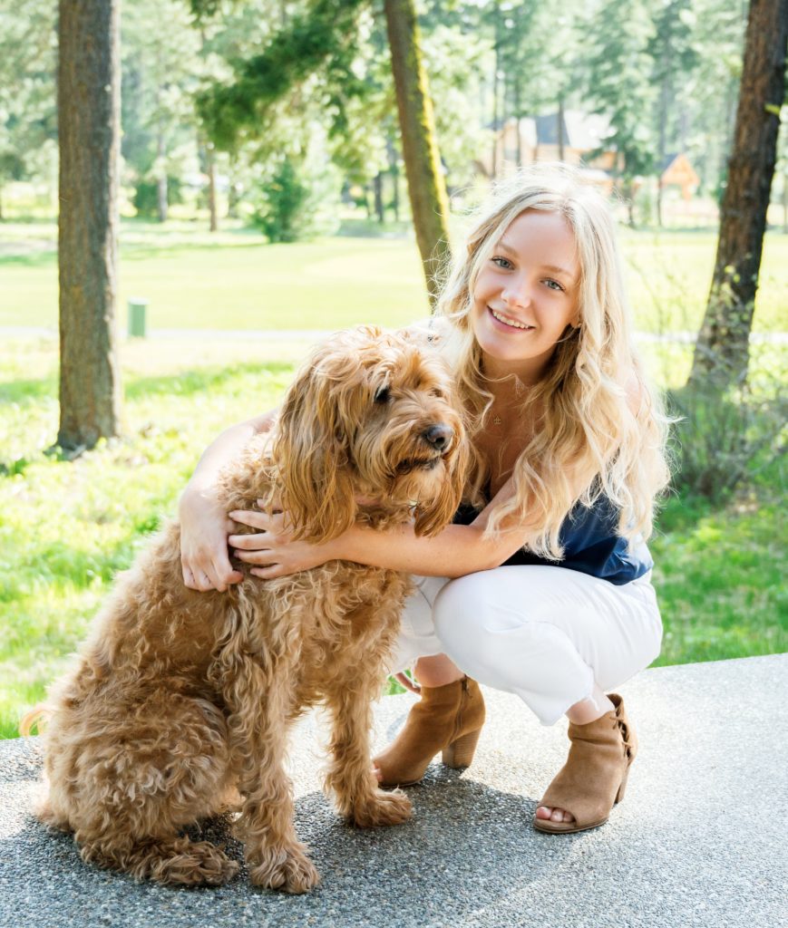Pretty blonde teenage girl holds family dog in Suncadia