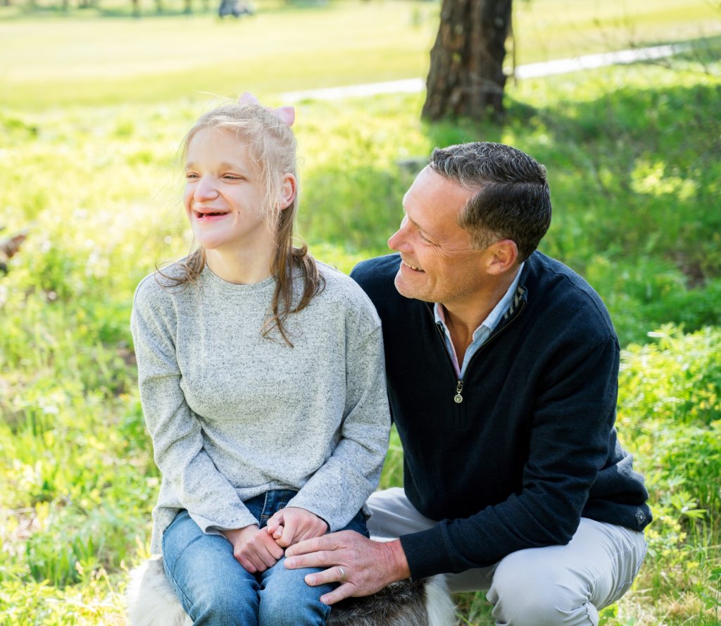 A father smiles lovingly at this daughter as she smiles into the distance during Suncadia family portrait session