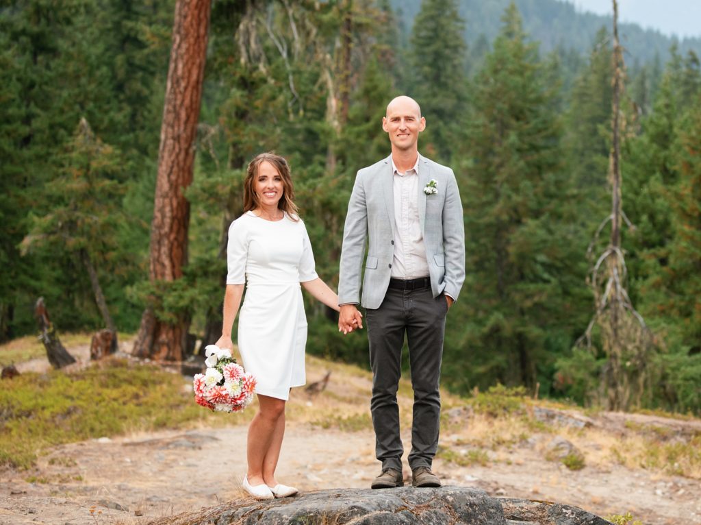 Bride and Groom stand in front of a wooded area during an Elopement at Lake Cle Elum