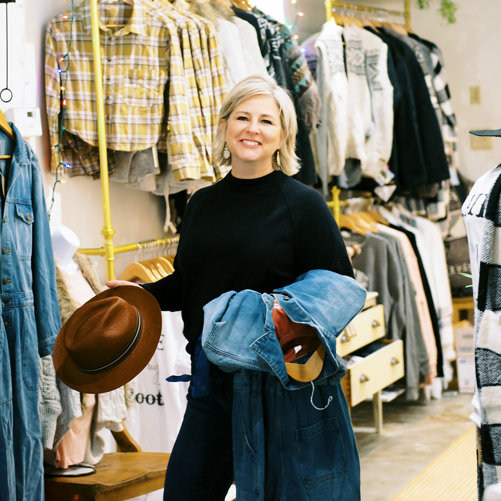 Blond Woman Holding Hat in boutique shop