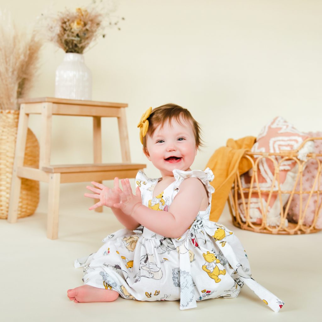 Studio photo by a Family Photographer in Ellensburg of a one year old baby girl clapping